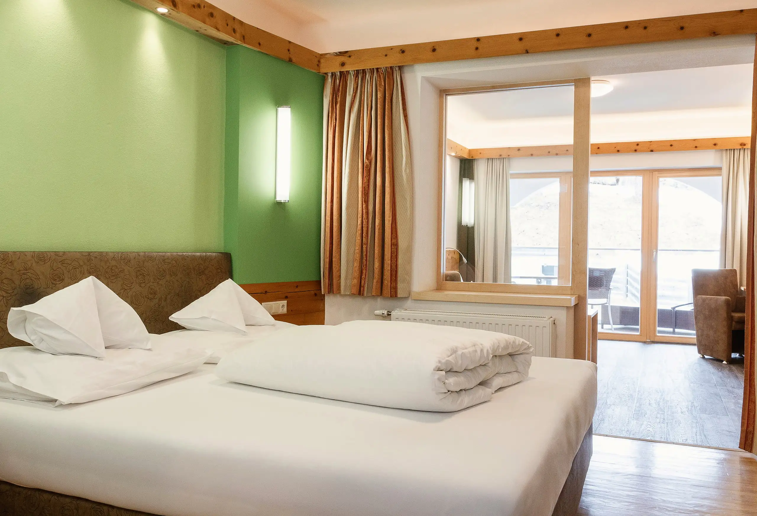 Juniorsuite König Ludwig mit Holzdecke und Balkontür im Schlosshotel Seewirt